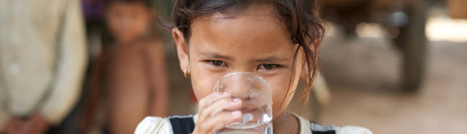 young girl drinking water from glass